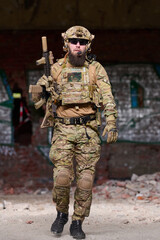 Obraz premium Tactical Soldier in Camouflage Gear Holding Rifle During Urban Patrol in Abandoned Building