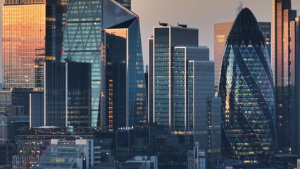United Kingdom, London: Aerial view of London skyline at sunset, modern glass skyscrapers and the distinctive shape of 30 St Mary Axe, commonly known as The Gherkin, amidst the bustling cityscape © Goinyk