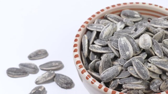 bol de graines tournesol grill&eacute;es et sal&eacute;es sur un fond blanc