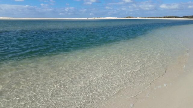 4k 30fps footage of the Heuningnes River estuary at De Mond Nature Reserve, Overberg, Western Cape. South Africa. Serene coastal wetlands, winding waterways and pristine nature under clear skies.
