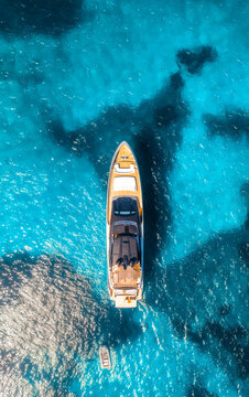 Aerial drone view of beautiful luxury yacht in blue sea in summer. Sardinia, Italy. Top down view of boat, sea bay with turquoise water. Tropical holiday. Yachting. Summer vacation and travel