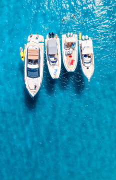 Aerial drone view of beautiful luxury yachts and boats in blue sea in summer. Sardinia, Italy. Top down view of speed boats, turquoise water. Tropical landscape. Yachting. Seascape. Summer vibe