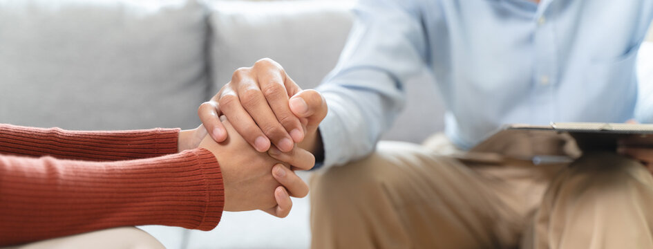 mental health issues concept, doctor touching patient hand showing empathy during depression therapy session.