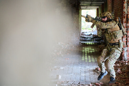Tactical Soldier in Camouflage Clearing an Abandoned Urban Building During Close Quarters Training Exercise