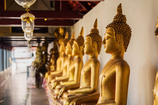 Beautiful rows of golden Buddha statues inside Wat Pho in Bangkok, Thailand.