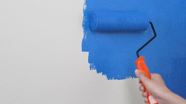 Painter is painting the interior wall blue.	