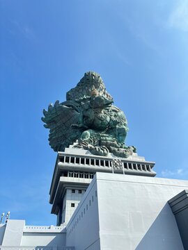 Low angle view of the massive Garuda Wisnu Kencana (GWK) statue against a clear blue sky in Bali.
