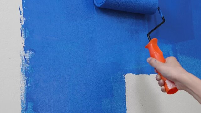 Painter is painting the interior wall blue.	