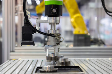 Obraz premium Industrial robotic arm with machine vision camera picking metal gears in automated factory line, Robotic gripper handling steel machine, Automated robotic system smart factory.