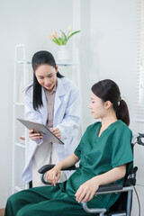 Obraz premium The doctor is talking to a patient in a wheelchair in the hospital.