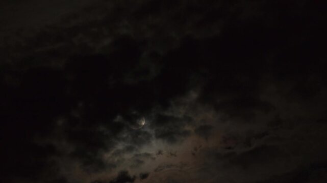 Moonlit clouds moving across full moon, timelapse night sky