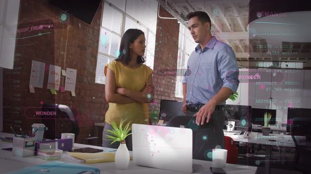 Male coworker gesturing while reviewing laptop, causing UI charts as woman clarifying business data