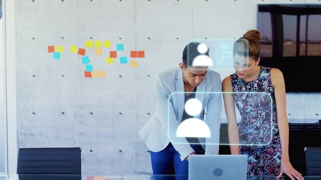 Two coworkers collaborating on laptop in business user icons appearing top-right floating on laptop