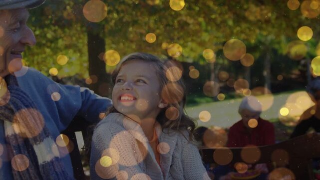 Child girl sitting bench smiling to Senior man touching shoulder panning left golden bokeh ad
