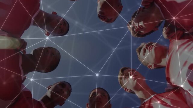 Male players forming sports huddle over groundcam planning in red kits while network linking faces