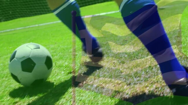Male soccer player pressing ball, kicking toward goal as translucent flag overlay obscuring player