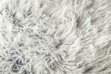 White fluffy faux fur texture background, soft shaggy carpet textile detail © qunamax