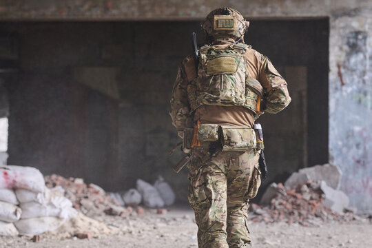 Military Soldier in Camouflage Gear Moving Through Abandoned Urban Building During Tactical Operation
