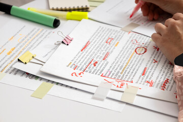 Student or editor analyzing written assignment with notes and highlights, checking text for accuracy, clarity and academic quality © uaPieceofCake