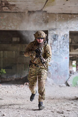 Obraz premium Armed Soldier Running Through Abandoned Building In Tactical Gear During Urban Combat Training Exercise