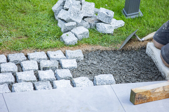 Cobblestone pavement installation with tools and groundwork preparation