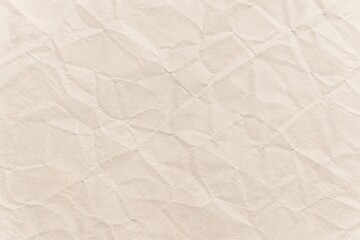 Fototapeta premium Soft beige crumpled paper texture background with realistic folds