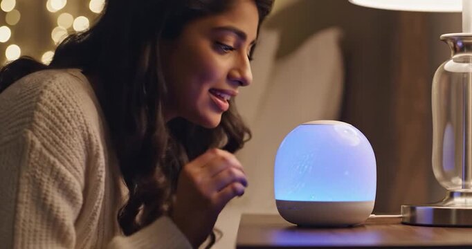Woman smelling essential oils from an ultrasonic diffuser at home