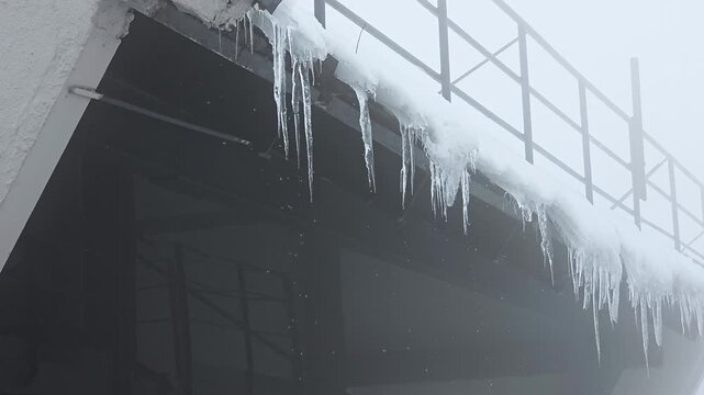 Frosty Building Edge Scene. Cold Urban Environment Featuring Icy Rooftops And Misty Atmosphere. Frosted Building Overhang With Dripping Icicles And Muted Monochrome Cityscape