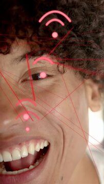 Vertical video: Man smiling into laugh, showcasing pink AR tech overlay aligning on cheek in car