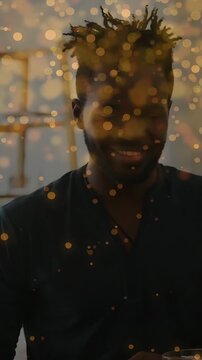 Vertical video: Man at table noticing peer entering, starting marketing chat amid golden bokeh
