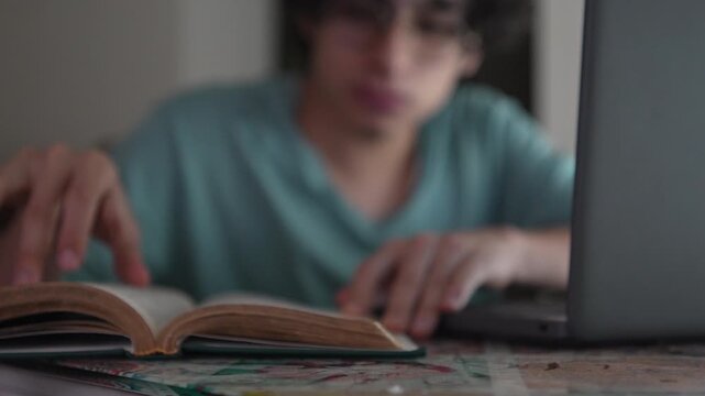 Gen Z Latino Student Turning Pages of a Reference Book while Studying, Concept of Education and Deep Learning