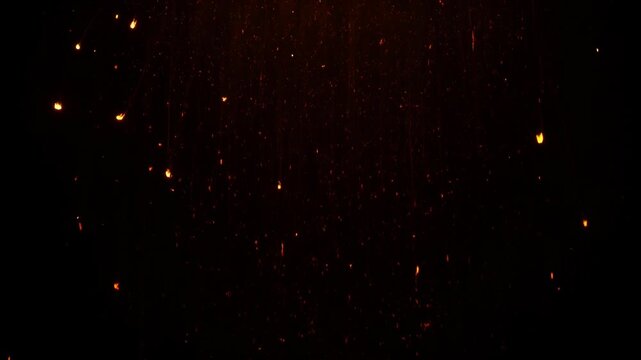 Abstract background of glowing embers and sparks floating in darkness, creating a magical and fiery atmosphere.