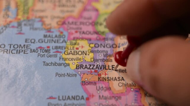 Hand Placing Red Pin on Brazzaville Congo Location in World Map Travel Concept