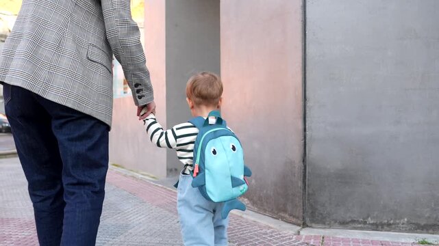 Mother and child walking to daycare holding hands