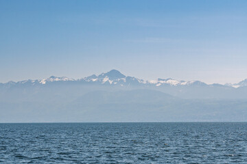 Obraz premium Sommets alpins se détachant au-dessus du lac Léman dans une brume légère.