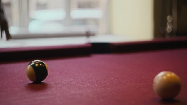 Close up on hands of unrecognizable Black man striking pool ball with cue sinking shot in billiards game, slow motion