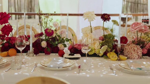 Elegant wedding decor, floral centerpiece, luxurious table with mixed roses, peonies, hydrangeas. Glasses, plates, cutlery, napkins. Wedding decor, holiday dinner or party.