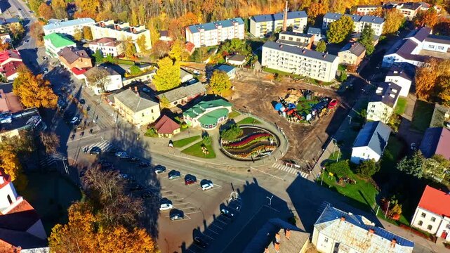 Town square undergoing transformation in an autumn setting in aerial view with colorful trees