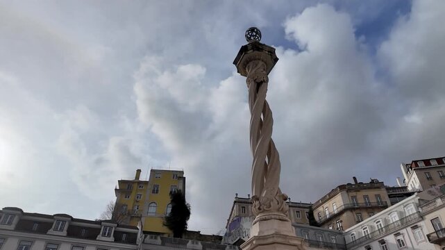 Street-level shot outside the historic Pillory of Lisbon in Pra&ccedil;a do Munic&iacute;pio, featuring classic architecture and an iconic landmark in Lisbon, Portugal.
