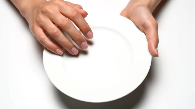 Hands holding white empty plate.
