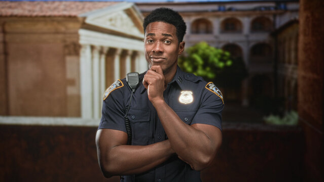 Man police officer in uniform with hand on chin and crossed arms at courthouse building entrance; duty reflection.