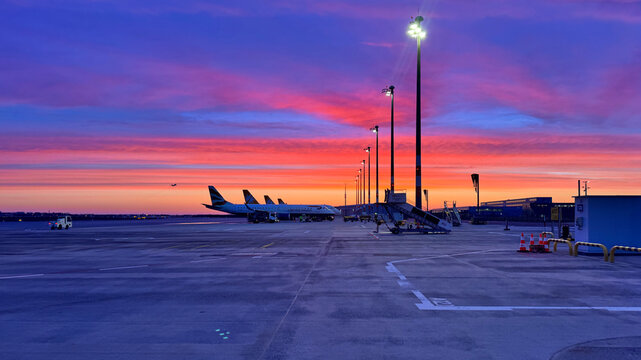 Airport apron at Berlin Brandenburg Airport with parked aircraft at dawn