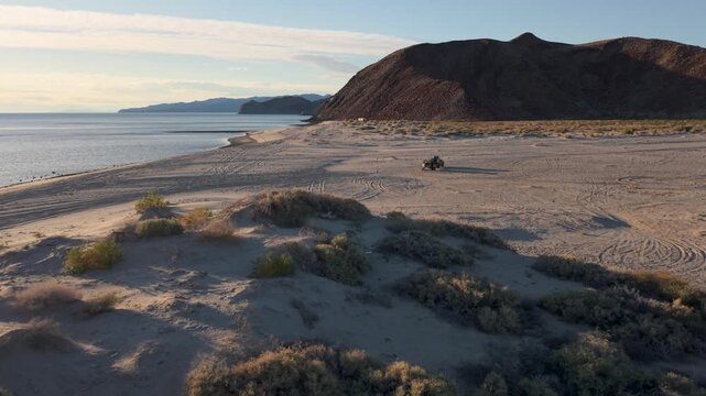Teardrop camper trailer sits on a beach near Papa Fernandez as the sun rises over the Sea of Cortez in Baja California, Mexico.