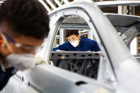  workers manufacture cars on an assembly line.
