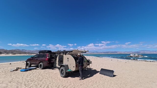 Setting up a teardrop camper trailer near the beach, preparing food and enjoying the morning sunshine in Baja California Mexico