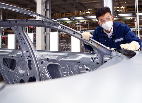  workers manufacture cars on an assembly line.