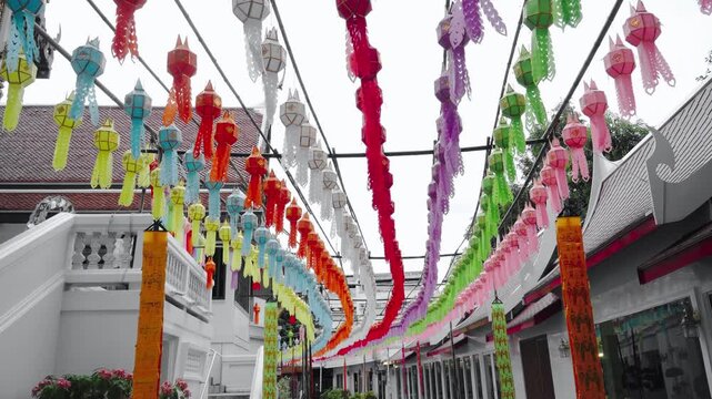 Colorful Thai paper Lanna lanterns are hanging in row in Buddhist temple Thailand, Loi Krathong Yi Peng festival.