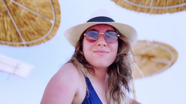 Young happy woman vlogging on a sunny greek beach