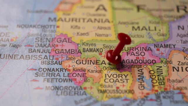 Hand Pointing Guinea with Red Pin on World Map 4K 60fps