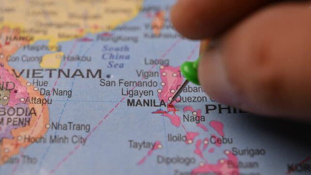 Hand Pointing Manila Philippines with Green Pin on World Map 4K 60fps